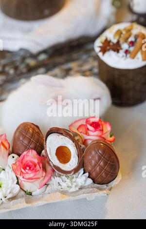 Chocolate Easter eggs with roses and white bunny, spring holiday still life Stock Photo