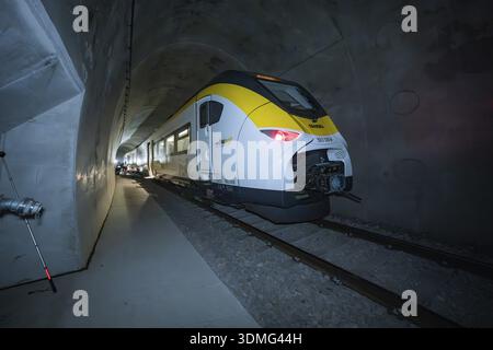 A brightly lit yellow-black train stands in a dark tunnel, fire department exercise on the Hermann Hesse Railway, Ostelsheim, Germany Stock Photo