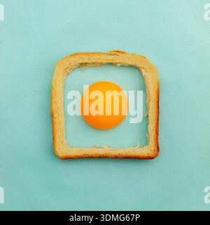 Eggs made of a ping pong ball and a crust bread of toast pastel blue background. Easter concept Stock Photo