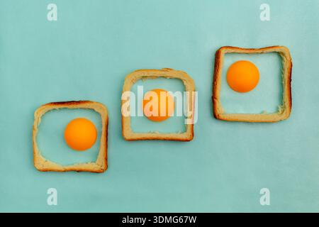 Eggs made of a ping pong ball and a crust bread of toast pastel blue background. Easter concept Stock Photo