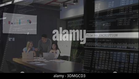 Discussing three colleagues in business casual, pointing at laptops in office, encryption overlay Stock Photo