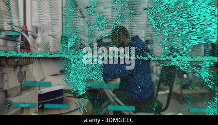 Sewing man in blue jacket operating machine at garment workshop, with teal particle overlay Stock Photo