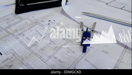 Displaying floor plans with blue caliper and pen on design desk, overlaid digital charts Stock Photo