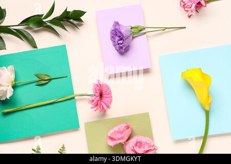 Composition with envelopes and different flowers on beige background Stock Photo