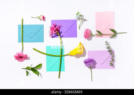 Composition with different envelopes and flowers on white background Stock Photo