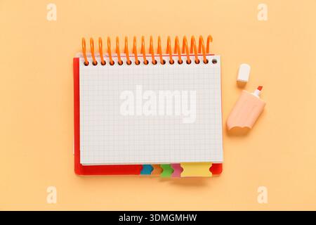 Blank open notebook and felt-tip pen on orange background Stock Photo