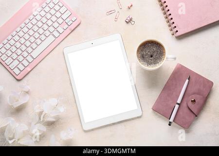 Composition with modern tablet computer, cup of coffee, keyboard and flowers on white grunge background Stock Photo