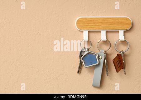 Rack with keys from house on beige wall Stock Photo