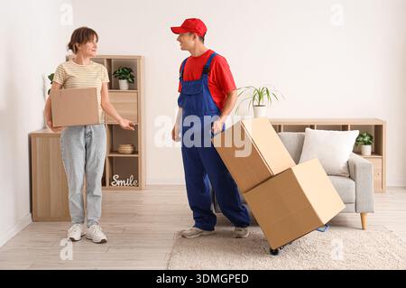 Young woman receiving parcels from delivery man at home Stock Photo