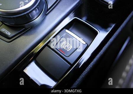 Electronic Parking Brake, A close-up of the electronic parking brake EPB button with the P symbol in a luxury vehicle console for secure stationary pa Stock Photo
