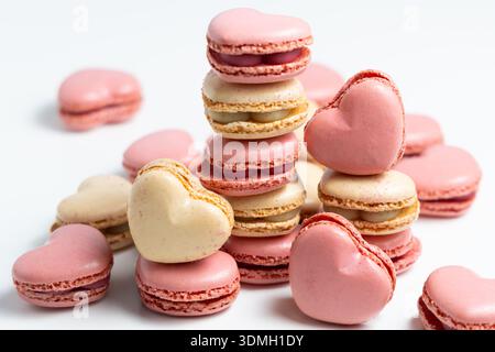 A group of heart-shaped macarons are placed together on a white surface. Stock Photo