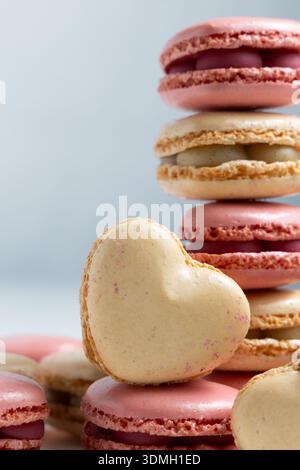 A display of macarons is arranged in a neat stack with various colors such as pink and beige. Stock Photo