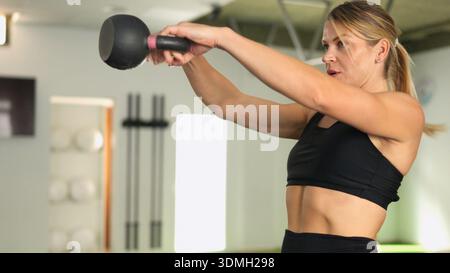 Woman training with kettlebell doing fitness workout Stock Photo