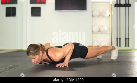 Woman exercising doing plank on gym floor Stock Photo
