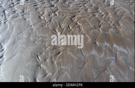 Natural patterns and textures created by water and wind on a sandy beach Stock Photo