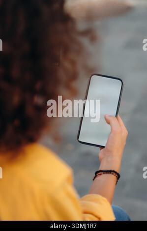 Woman is sitting and holding copy space smartphone, internet connection conception. Stock Photo