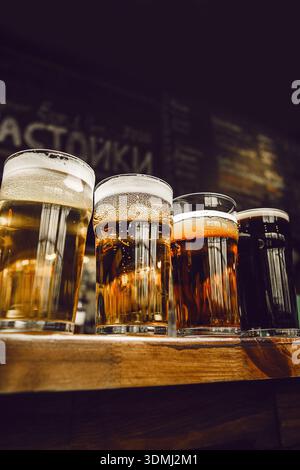 Close up View of Assorted Beer Glasses on Wooden Bar Counter Stock Photo