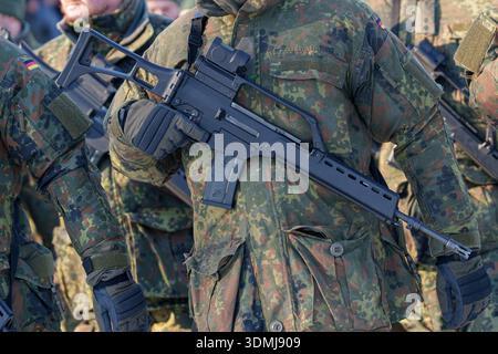 Close-up of a German soldier in flecktarn camouflage uniform holding a G36 assault rifle. Stock Photo