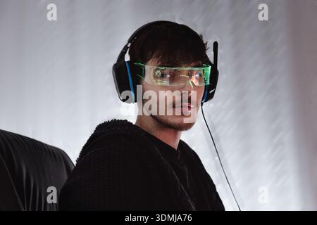 Young man using computer with led cyber glasses and headphones Stock Photo