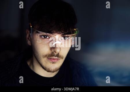 Young man using computer with led cyber glasses Stock Photo