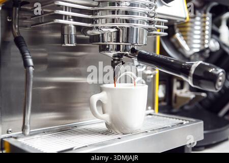 Espresso Machine Pouring Fresh Coffee Into White Cup in Cafe Setting Stock Photo