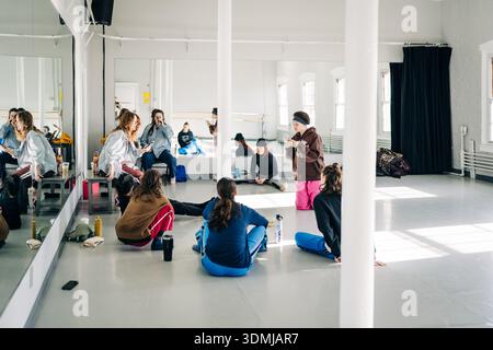 Group of dancers listening to instructor in studio Stock Photo