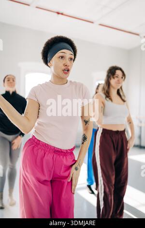 Dance instructor leading exercise class with diverse students Stock Photo