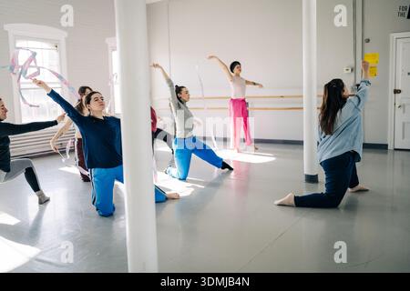 Women dancers practicing rhythmic movement with ribbons in studio Stock Photo
