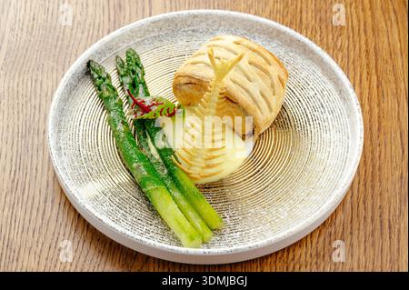 homemade fish pie on a plate with asparagus and sauce Stock Photo