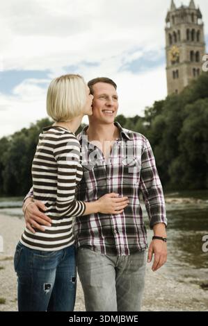 Young couple standing close together on a riverside Stock Photo