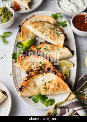 Close up of platter of beef and bean tacos with guacamole, salsa. Stock Photo