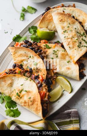 Close up of platter of beef and bean tacos with guacamole, salsa. Stock Photo