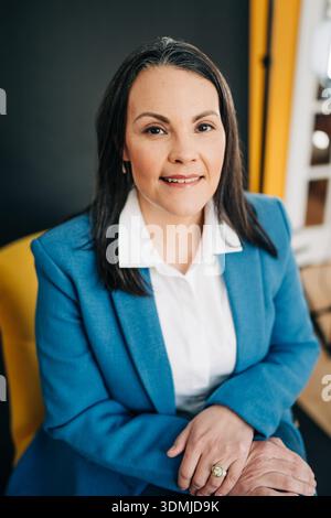 Woman smiling confident in blue corporate blazer headshot Stock Photo