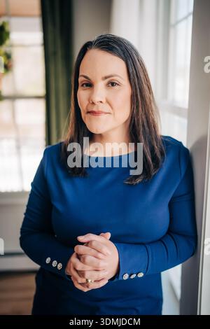 Professional woman standing with hands clasped Stock Photo