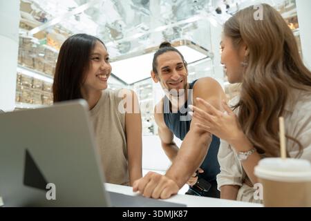 Diverse friends collaborating and discussing ideas on laptop Stock Photo