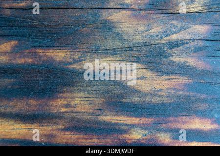 Abstract close up of a wooden surface with visible grain and layered blue and brown tones. Stock Photo
