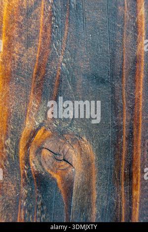 Close up of a wooden surface featuring a distinct knot and flowing grain patterns. Stock Photo