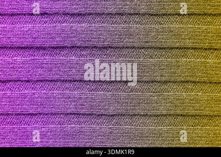 Cozy knitted fabric background with trendy vibrant purple and gold gradient. Professional textile background for fashion visuals, winter-themed design Stock Photo