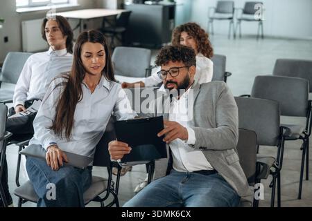 Looking forward, sitting. People are sitting on the meeting, education presentation, business conception. Stock Photo