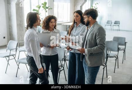 Smart employees are having conversation. Group of people are working in the office together as a team. Stock Photo