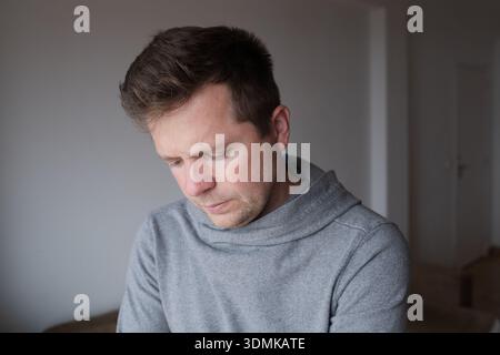 Sad and disappointed young man looking down with a feeling of hopelessness Stock Photo