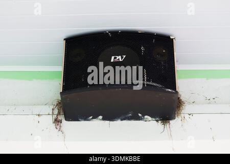 Sabah, Malaysia - January 27th, 2026: A close-up shot of an outdoor "PV Audio" brand speaker mounted on a wall with bird nests built into the corners, Stock Photo