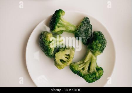 Frozen broccoli on a white plate. High quality photo Stock Photo