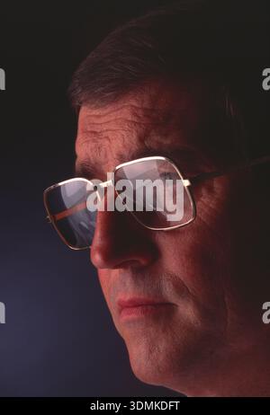Middle-aged man, wearing spectacles with computer screen reflection. Stock Photo