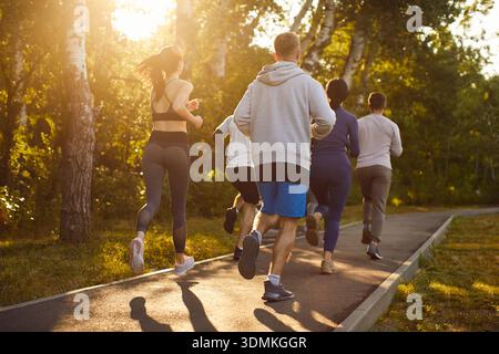 Runners training, young people running marathon together through green park Stock Photo