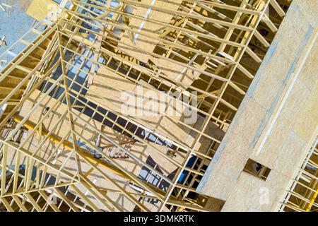 Workers assemble wooden beams frames on construction site for new building in city Stock Photo