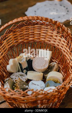soap assortment in gift basket, decorative gift basket filled with assorted handcrafted soap bars Stock Photo