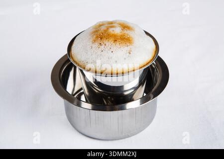 Freshly brewed South Indian filter coffee, also known as degree coffee, served in a stainless steel tumbler and davara, isolated on a white background Stock Photo