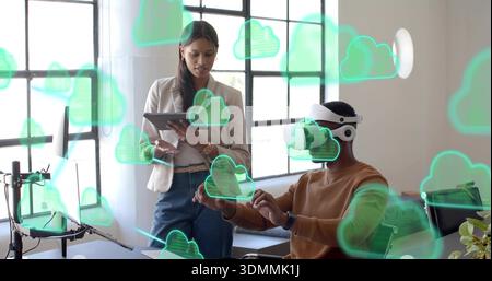 Testing man wearing white VR headset and blazer-clad woman with tablet moving cloud icons in office Stock Photo