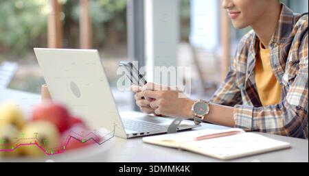 Checking smartphone, plaid shirt man typing on laptop at window with notes, wristwatch, copy space Stock Photo